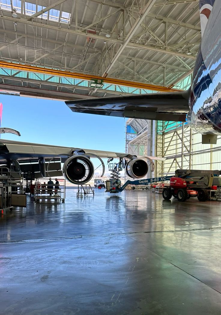 Wide-body aircraft undergoing checks inside a maintenance hangar